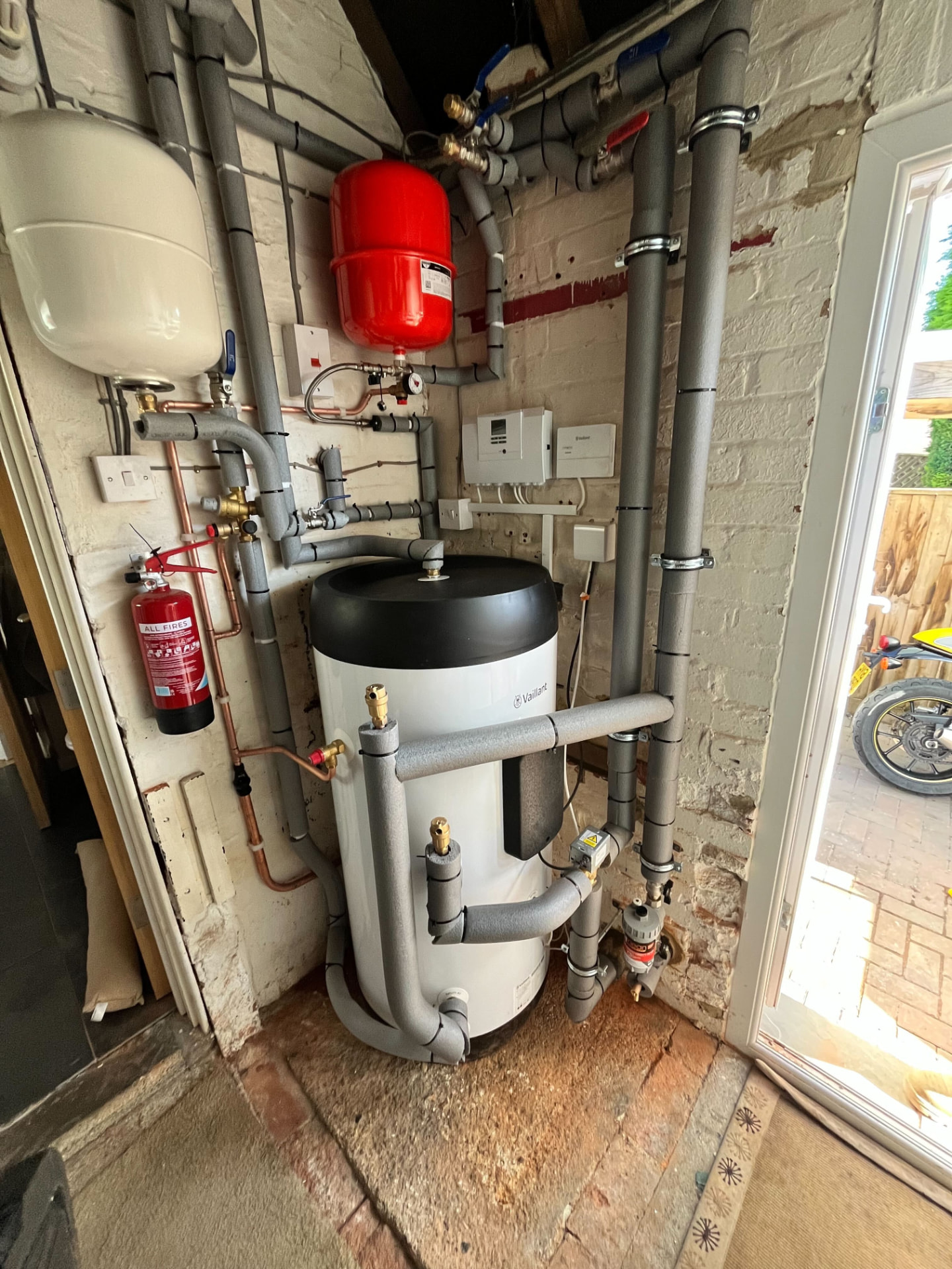 Modern unvented hot water cylinder in a UK airing cupboard.
